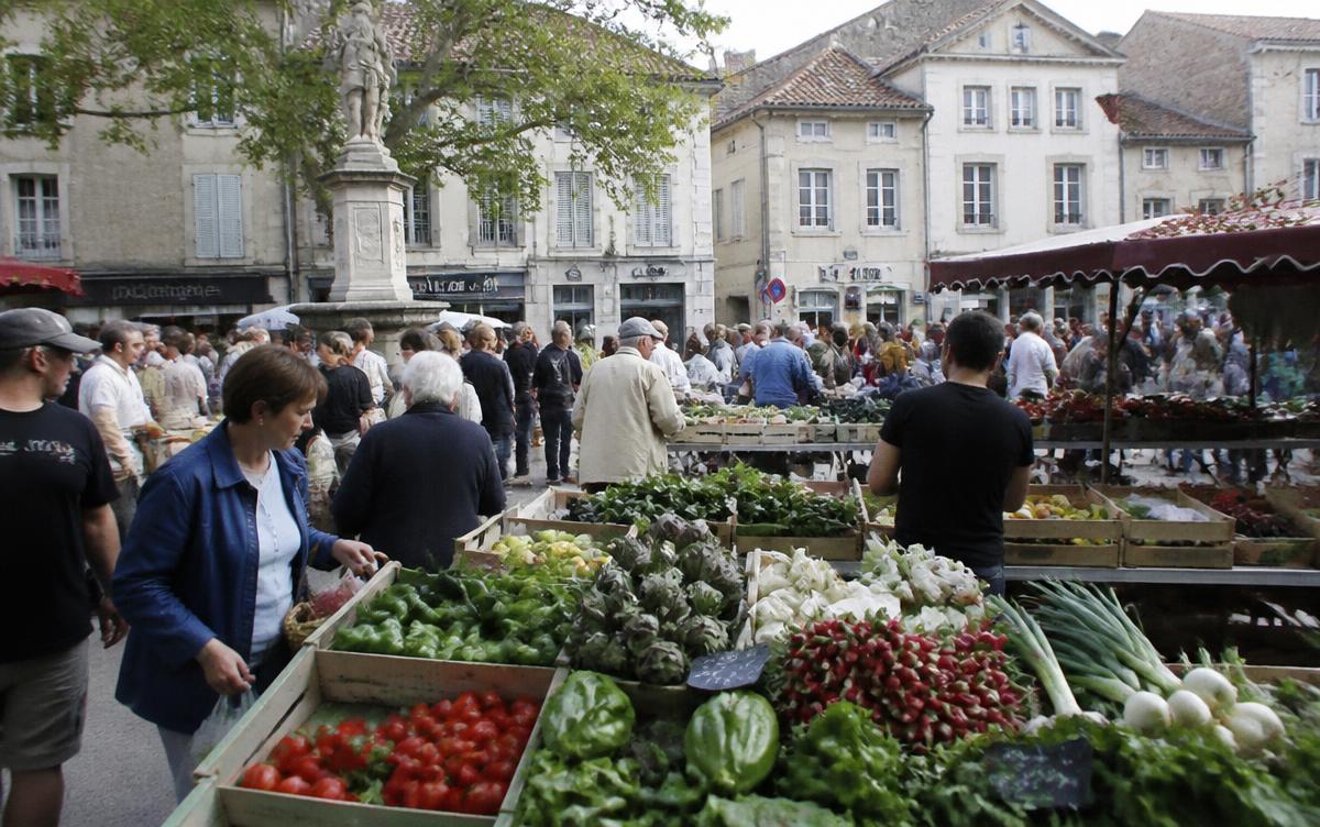 Marché de village français avec étals de fruits et légumes