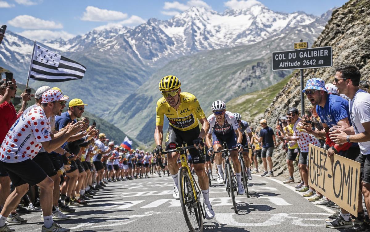 Cyclistes escaladant un col de montagne encouragés par la foule
